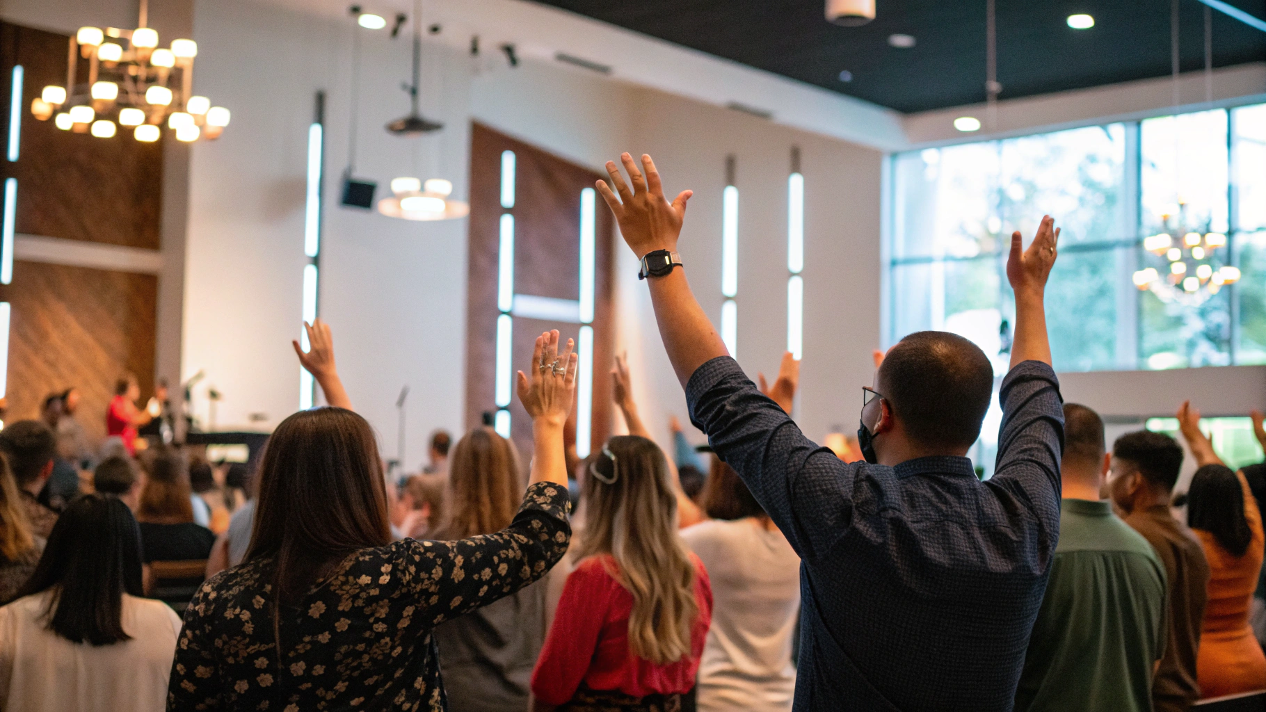Diverse congregation with hands raised in worship